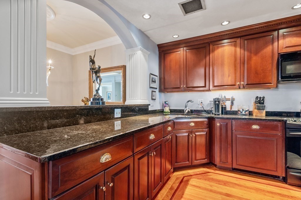 197 8th Street, Unit 711 Boston, MA 02129 - Photo 11 of 24 a kitchen with stainless steel appliances granite countertop a sink stove and cabinets