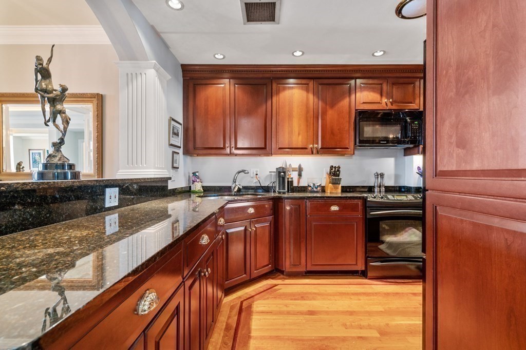 197 8th Street, Unit 711 Boston, MA 02129 - Photo 12 of 24 a kitchen with stainless steel appliances granite countertop a stove a sink and a microwave