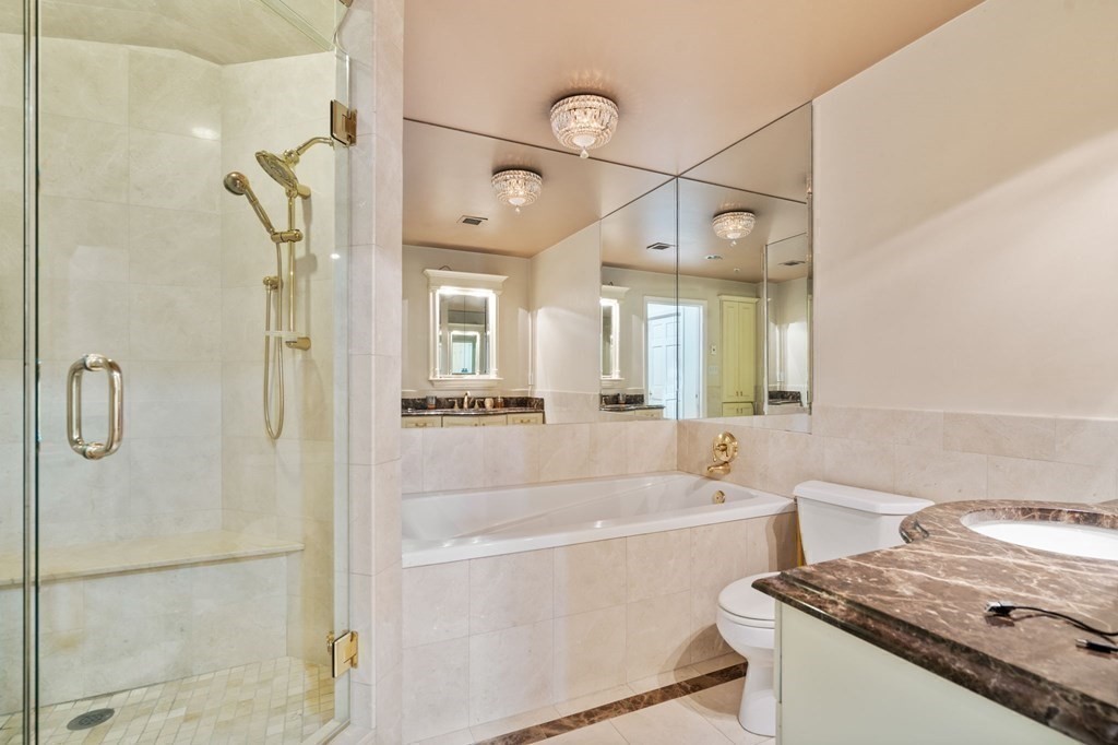 197 8th Street, Unit 711 Boston, MA 02129 - Photo 16 of 24 a bathroom with a tub a sink and a large mirror