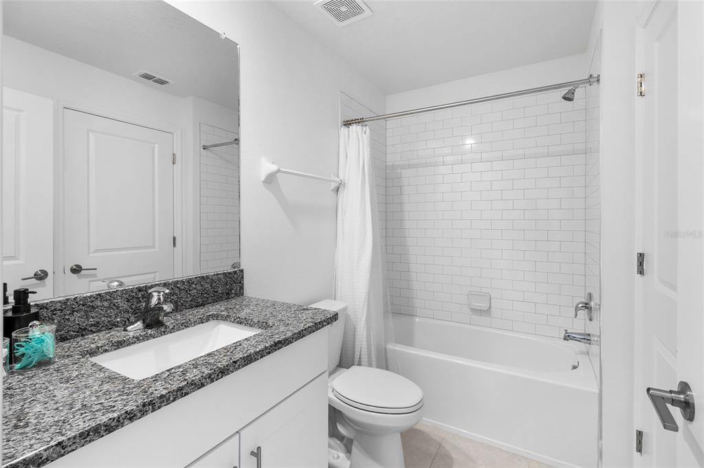 14450 Easy Goer Street Ruskin, FL 33573 - Photo 21 of 27 a bathroom with a granite countertop sink toilet and shower