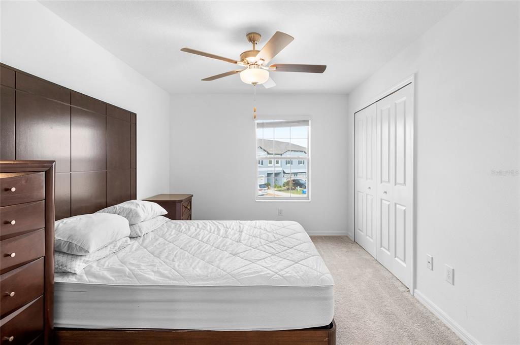 14450 Easy Goer Street Ruskin, FL 33573 - Photo 22 of 27 a bedroom with a large bed and a chandelier