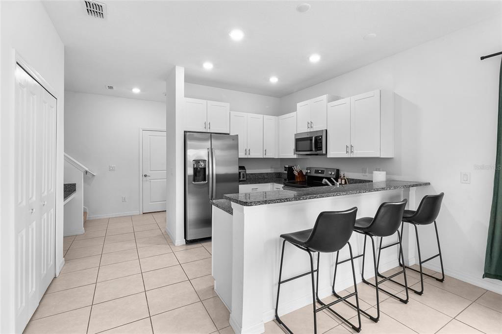 14450 Easy Goer Street Ruskin, FL 33573 - Photo 6 of 27 a kitchen with stainless steel appliances granite countertop a refrigerator and a stove top oven