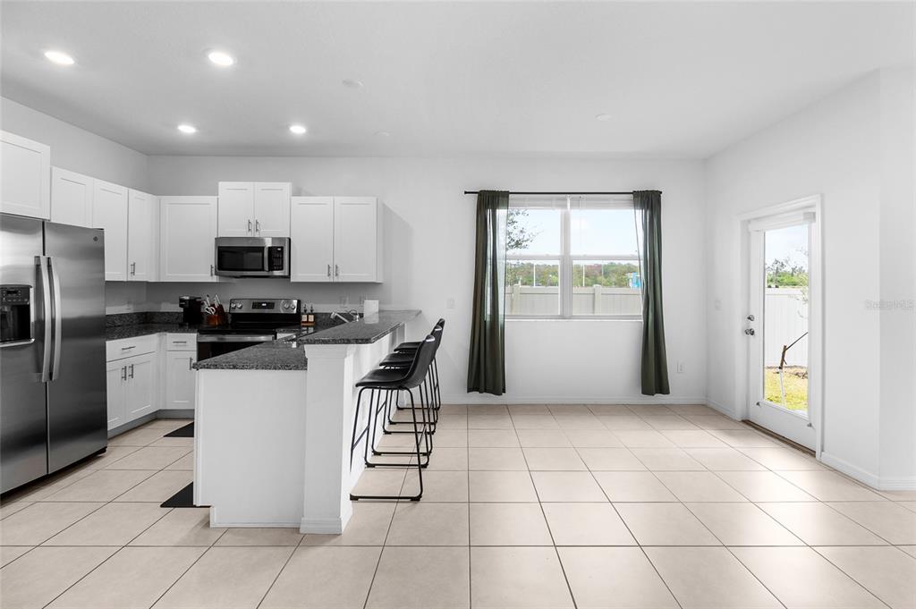 14450 Easy Goer Street Ruskin, FL 33573 - Photo 9 of 27 a kitchen with a sink a counter top space cabinets and stainless steel appliances