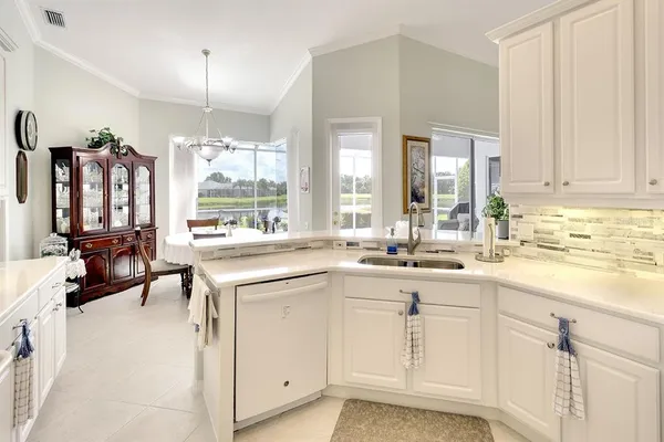 a kitchen with white cabinets and sink