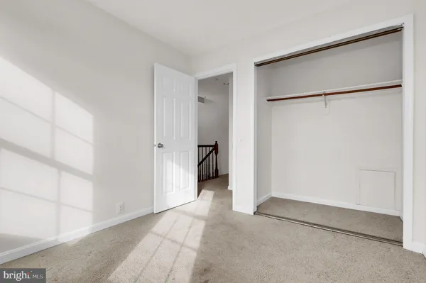 a bedroom with a bed a couch and a large window