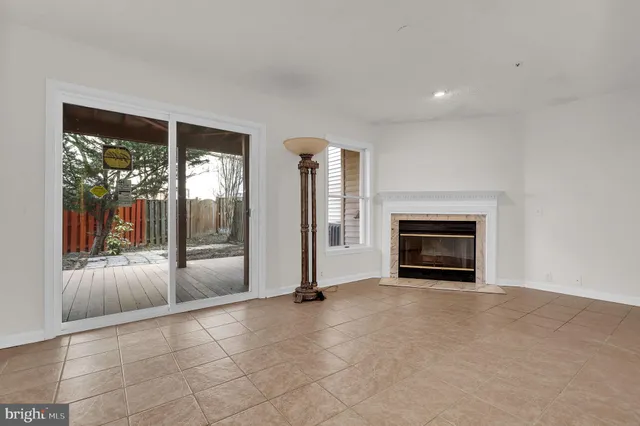 a view of an empty room with window and fire place