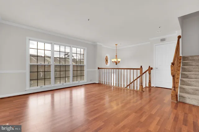 a view of a room with wooden floor and windows