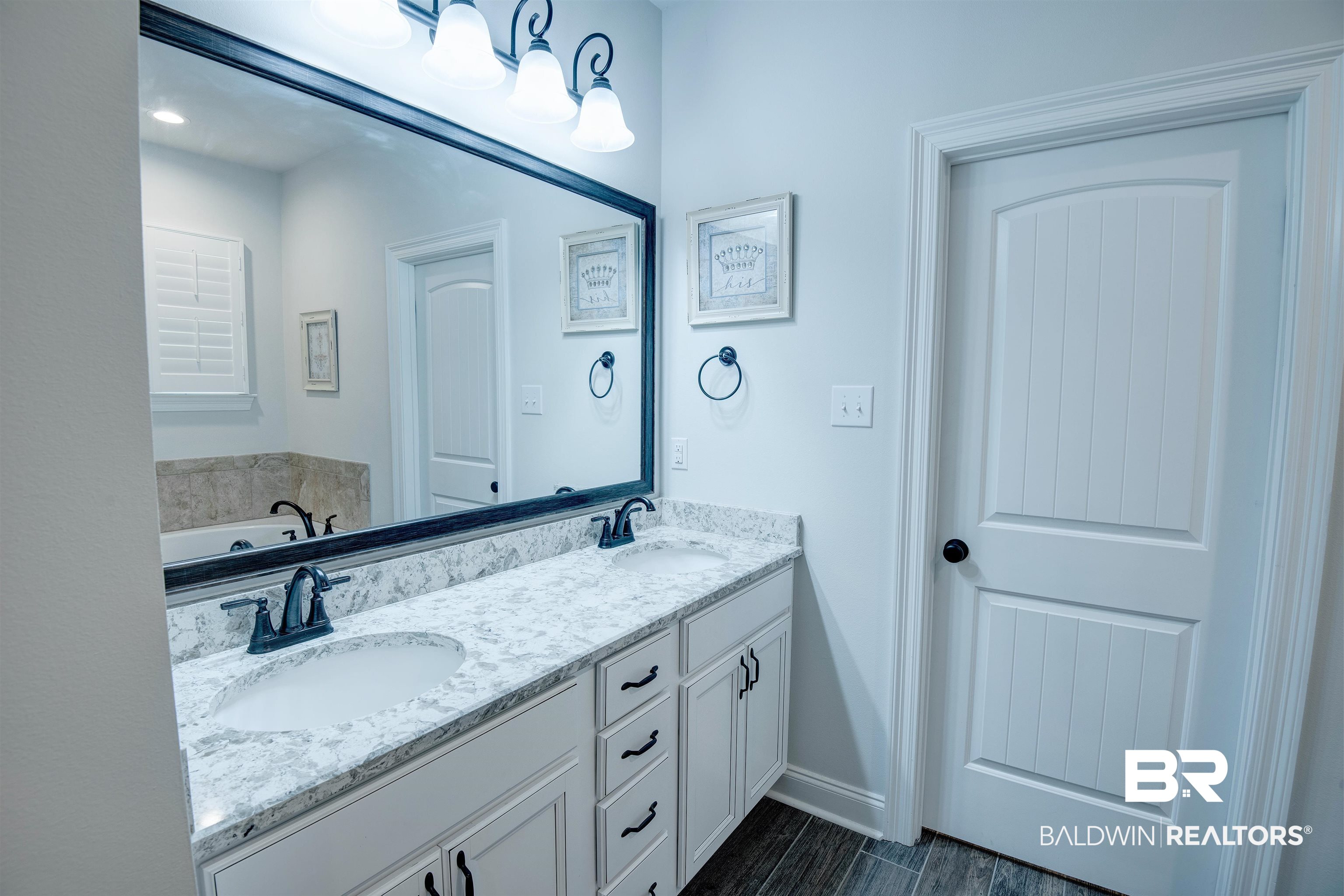9843 Chipper Lane Foley, AL 36535 - Photo 16 of 34 Full bath featuring double vanity, a garden tub, baseboards, and wood finished floors