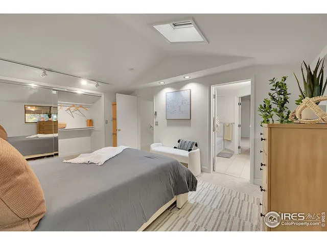 a bedroom with a bed and a large mirror