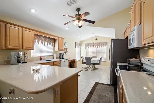 a kitchen with granite countertop a sink a counter top space appliances and cabinets