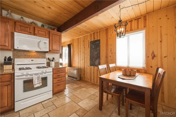 a kitchen that has a stove a table and chairs in it
