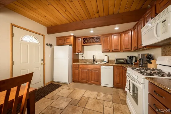 a kitchen with a refrigerator a stove top oven a sink and dishwasher with kitchen countertops