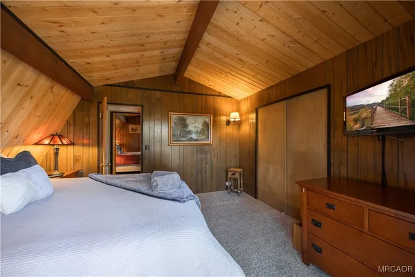 a bedroom with a bed and a dresser with mirror