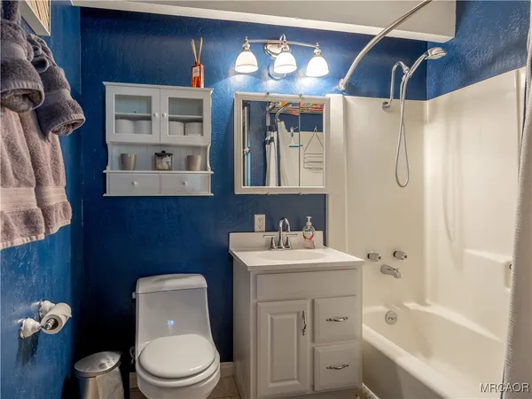 a bathroom with a toilet sink vanity tub and mirror