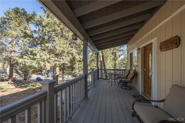 a balcony with wooden floor and outdoor seating