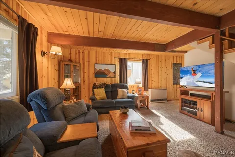 a living room with furniture a large window and a chandelier