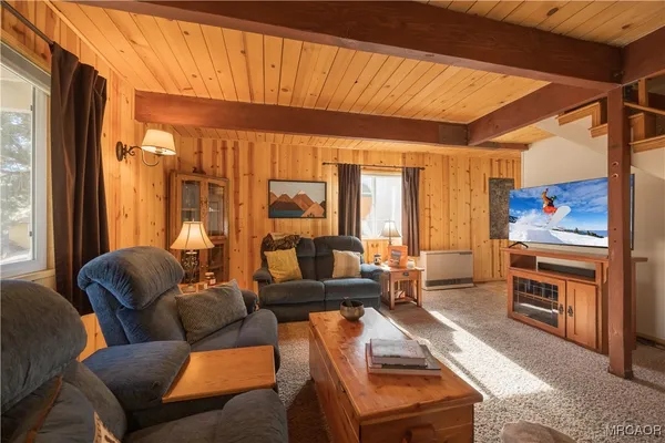 a living room with furniture a large window and a chandelier
