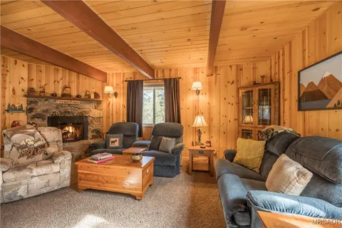 a living room with furniture a fireplace and a large window