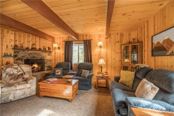 a living room with furniture a fireplace and a large window