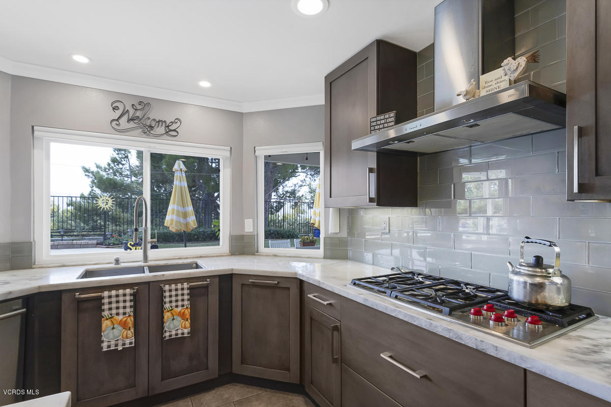 5438 Cochise Street Simi Valley, CA 93063 - Photo 12 of 35 a kitchen with stainless steel appliances granite countertop a stove a sink and a microwave