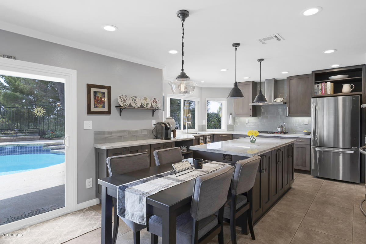5438 Cochise Street Simi Valley, CA 93063 - Photo 15 of 35 a kitchen with stainless steel appliances granite countertop a kitchen island a stove a table and chairs