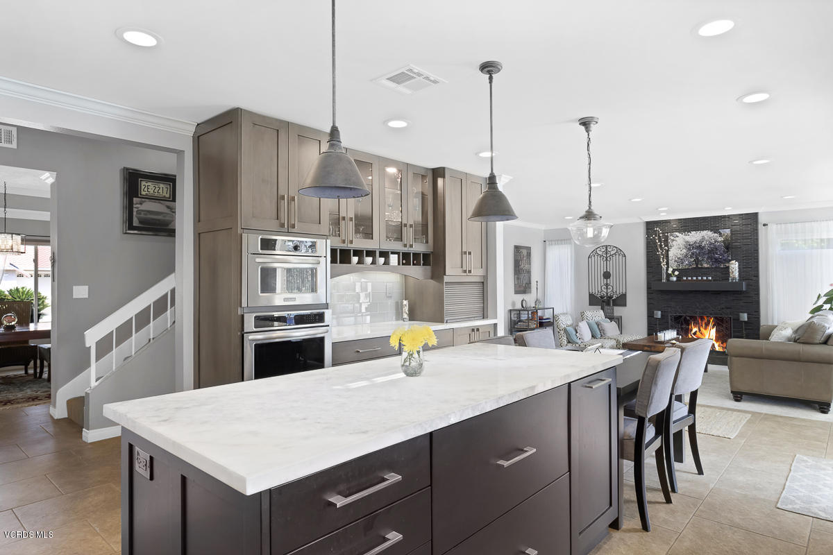 5438 Cochise Street Simi Valley, CA 93063 - Photo 16 of 35 a kitchen with stainless steel appliances kitchen island granite countertop a table chairs and a kitchen view