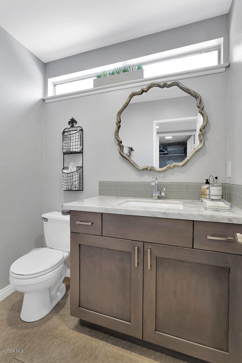 5438 Cochise Street Simi Valley, CA 93063 - Photo 21 of 35 a bathroom with a toilet a sink and mirror