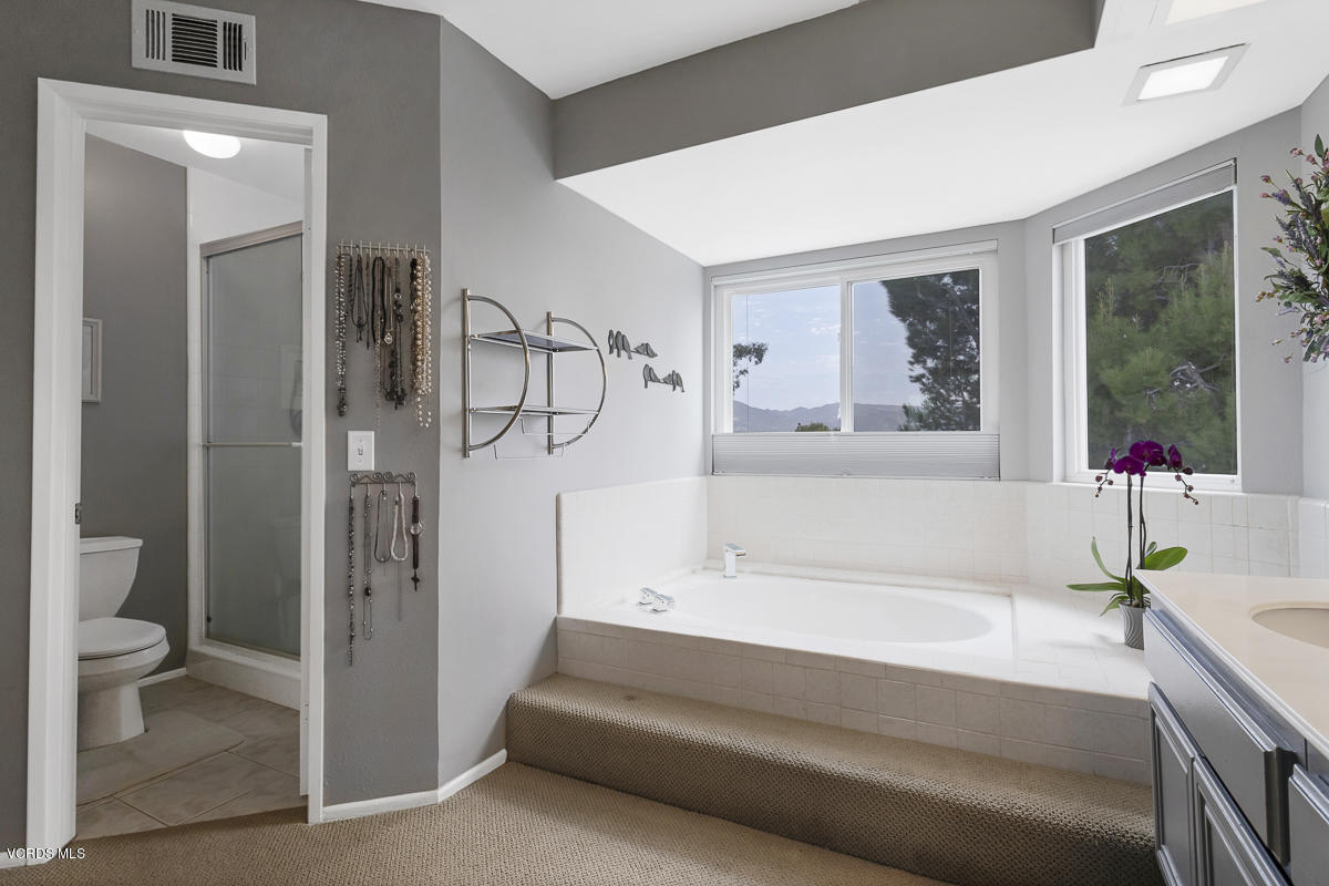 5438 Cochise Street Simi Valley, CA 93063 - Photo 28 of 35 a bathroom with a tub a sink and a large mirror