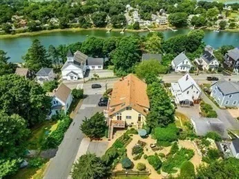 an aerial view of a house with a yard and lake view