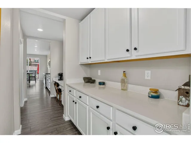 a kitchen with white cabinets and sink