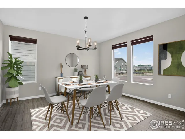 a view of a dining room and livingroom with furniture wooden floor a chandelier