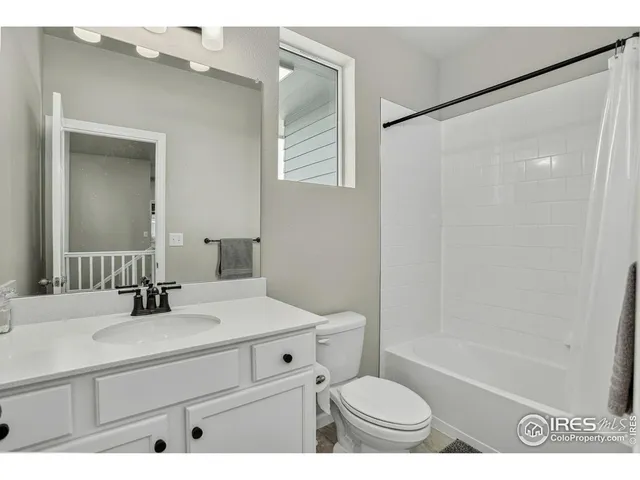 a bathroom with a sink a toilet a mirror and shower