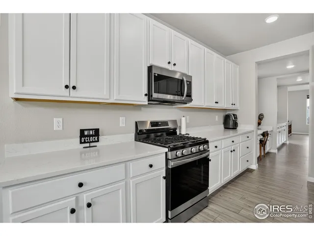 a kitchen with stainless steel appliances granite countertop a stove a sink and white cabinets
