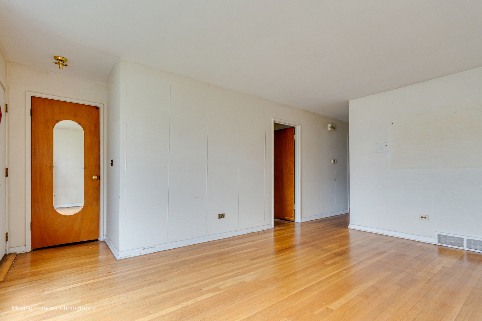 9726 S Lane Chicago, IL 60628 - Photo 11 of 27 an empty room with wooden floor and mirror