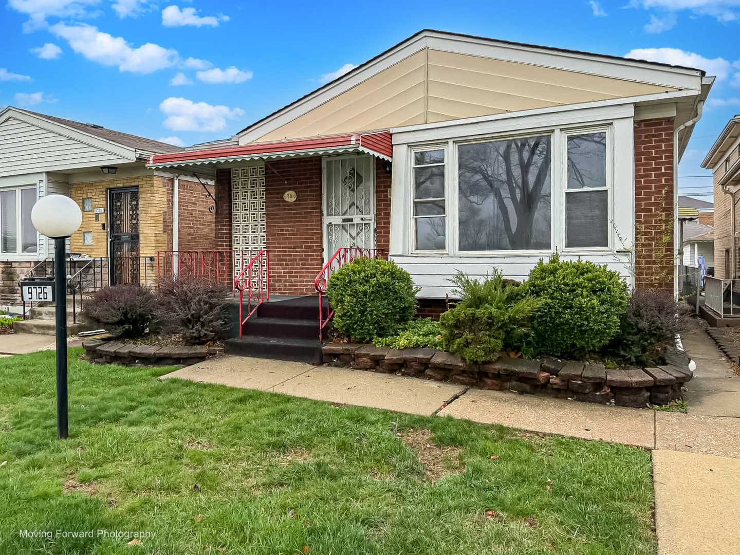 9726 S Lane Chicago, IL 60628 - Photo 5 of 27 a front view of a house with a yard and porch