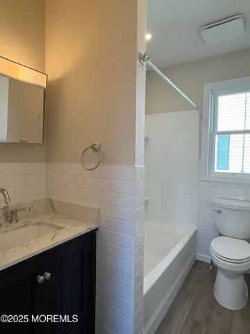 a bathroom with a sink vanity granite and toilet