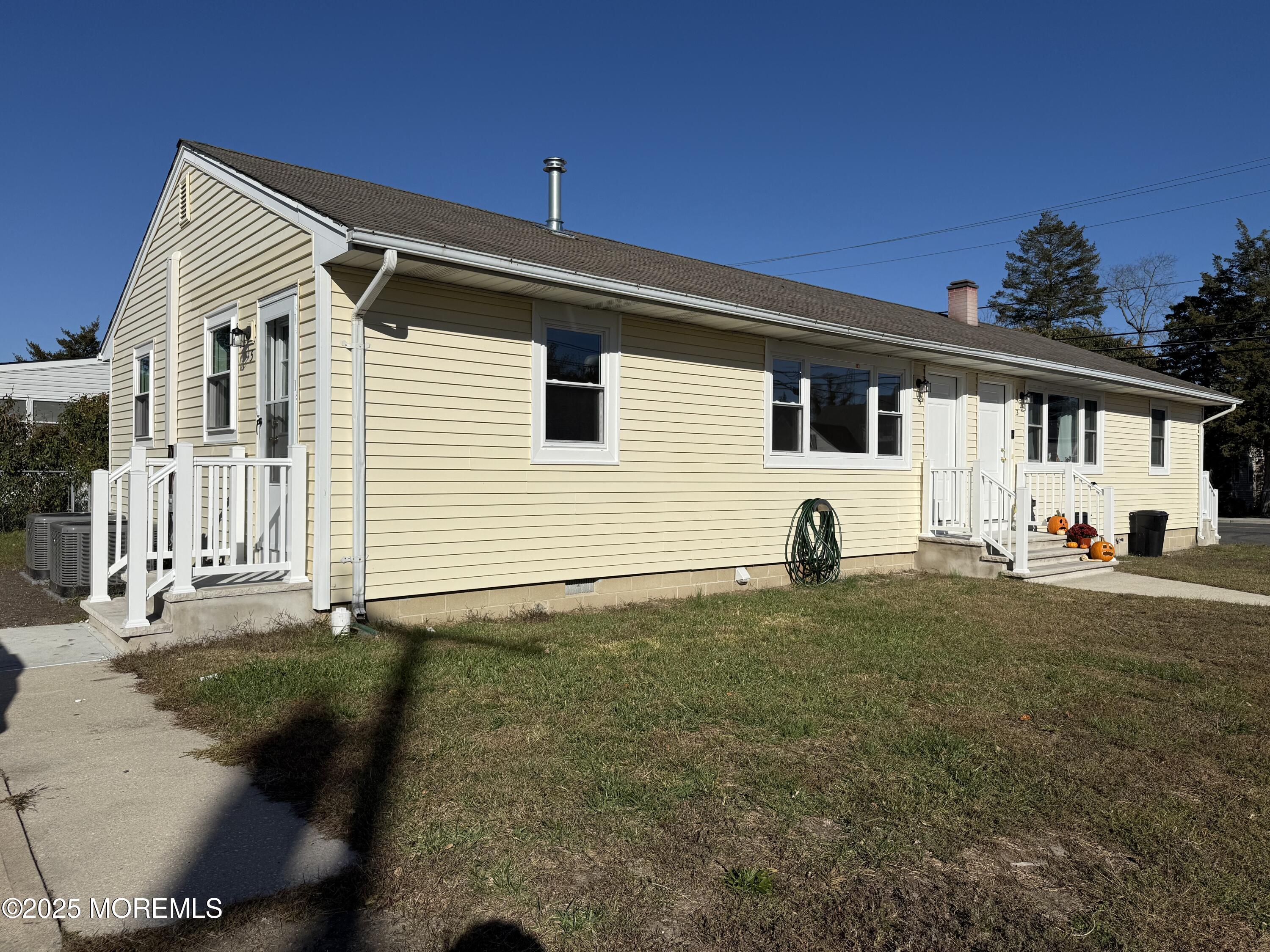 616 Ocean Gate Avenue, Unit 5 Ocean Gate, NJ 08740 - Photo 4 of 15 a view of a white house with a yard