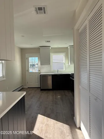 a view of a room with a window and wooden floor