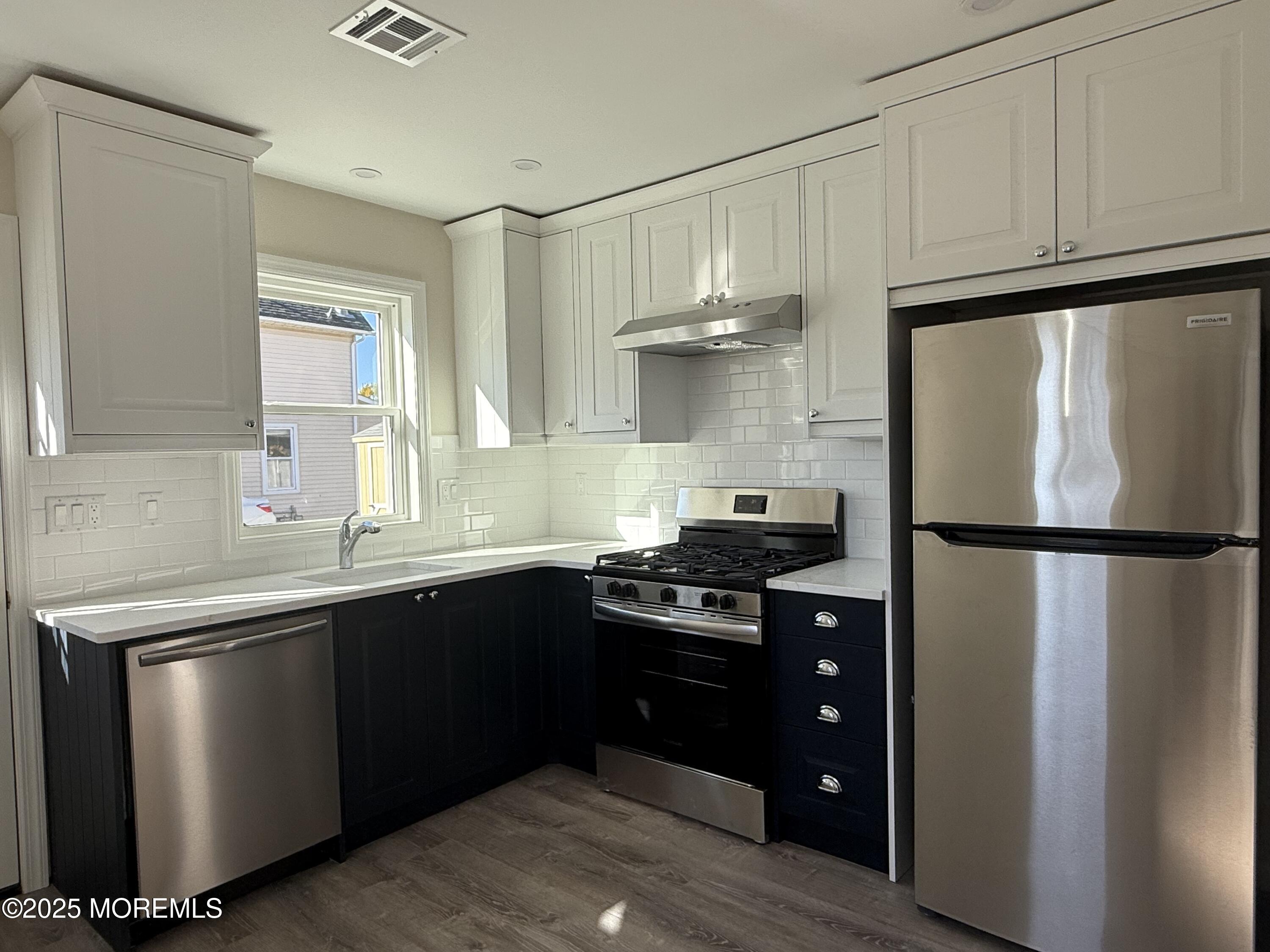 616 Ocean Gate Avenue, Unit 5 Ocean Gate, NJ 08740 - Photo 9 of 15 a kitchen with a sink a refrigerator and cabinets