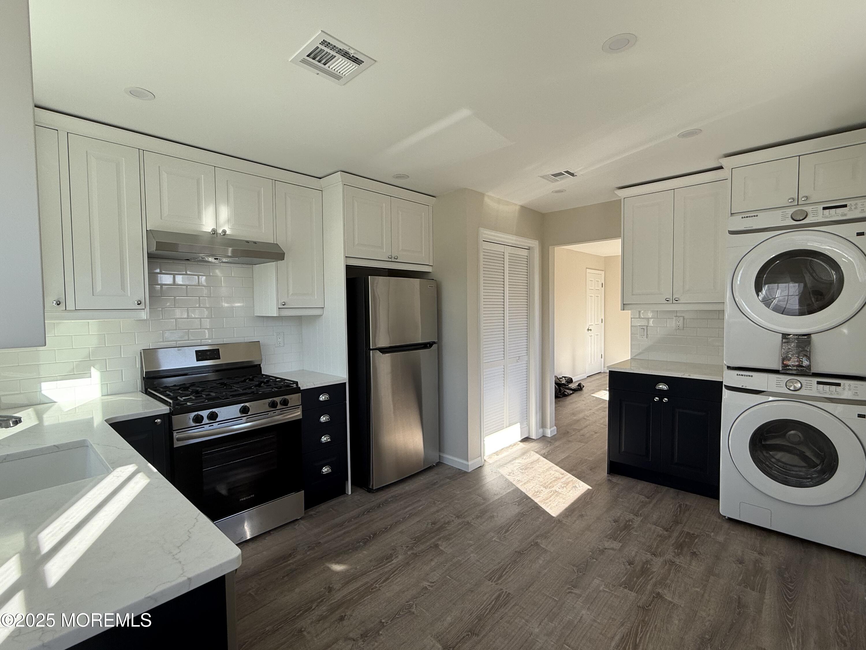 616 Ocean Gate Avenue, Unit 5 Ocean Gate, NJ 08740 - Photo 10 of 15 a kitchen with kitchen island wooden cabinets and stainless steel appliances