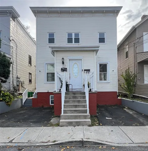 a front view of a house with potted plants