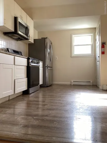 a view of a kitchen with wooden floor and electronic appliances