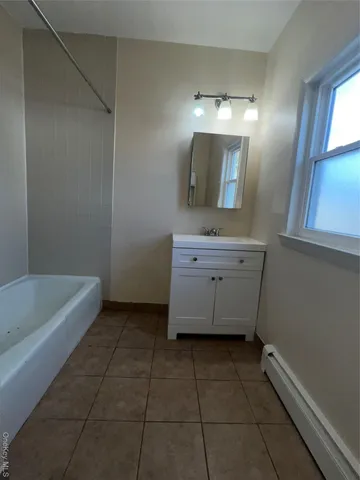 a bathroom with a bathtub a mirror a vanity and a bathtub