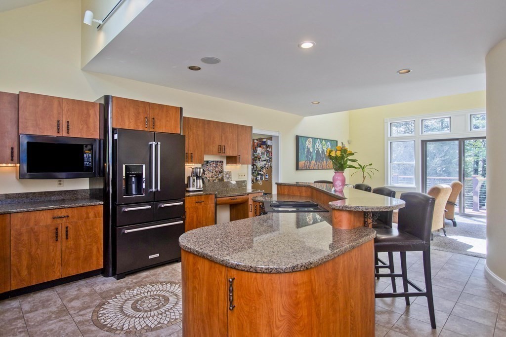 31 Rustlewood Ridge Northampton, MA 01062 - Photo 12 of 42 a kitchen with stainless steel appliances granite countertop a refrigerator a stove top oven a dining table and chairs