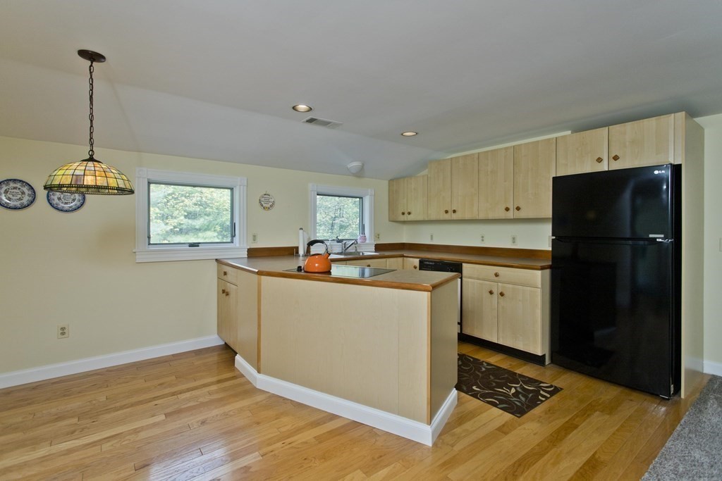 31 Rustlewood Ridge Northampton, MA 01062 - Photo 29 of 42 a kitchen with stainless steel appliances granite countertop a refrigerator a sink dishwasher a stove and white countertops with wooden floor