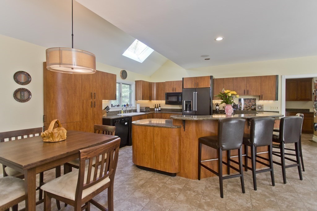 31 Rustlewood Ridge Northampton, MA 01062 - Photo 9 of 42 a dining room with stainless steel appliances kitchen island granite countertop a table chairs and a refrigerator