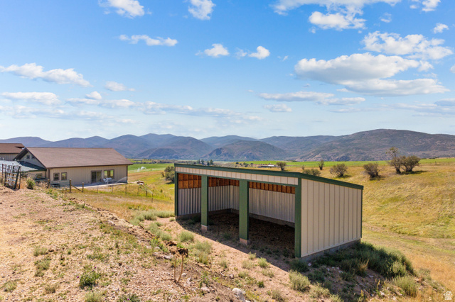 6117 North Rocky Ridge Road Peoa, UT 84061 - Photo 77 of 82 Open-sided metal structure with a green trim roof and posts, situated on an expansive, gently sloping landscape