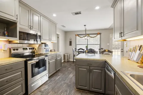 a kitchen with a sink appliances and cabinets