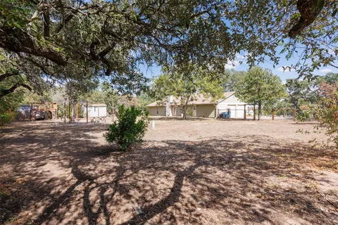 a front view of a house with a yard and trees