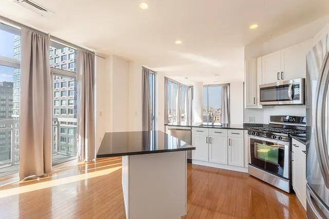 a kitchen with stainless steel appliances granite countertop a stove a sink and a microwave